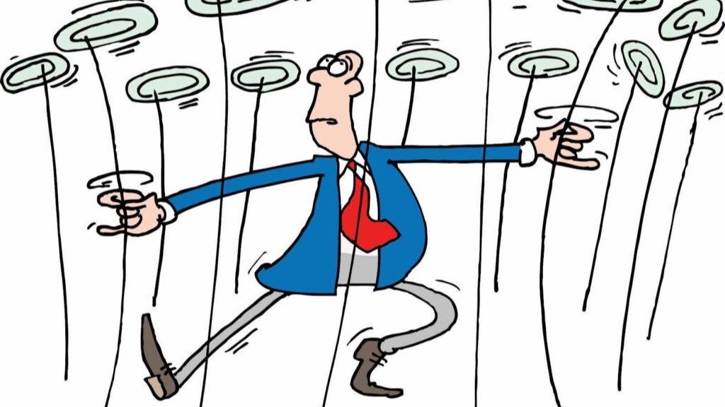 spinning plates A man in a blue suit and red tie amongst many plates he is spinning.